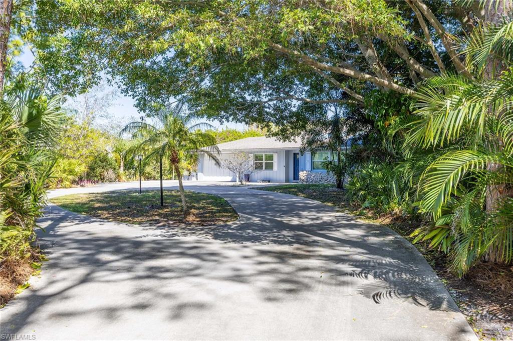 6574 Trail Boulevard Naples, FL 34108 - Photo 12 of 40 a view of a yard with plants and trees