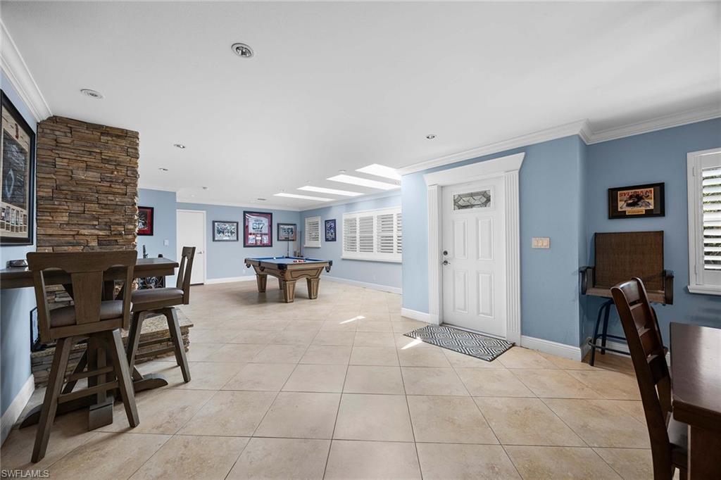 6574 Trail Boulevard Naples, FL 34108 - Photo 13 of 40 a living room with furniture and a large window
