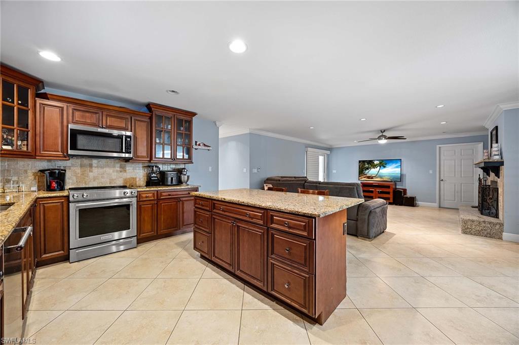 6574 Trail Boulevard Naples, FL 34108 - Photo 17 of 40 a kitchen with stainless steel appliances granite countertop a stove top oven a sink dishwasher and a refrigerator