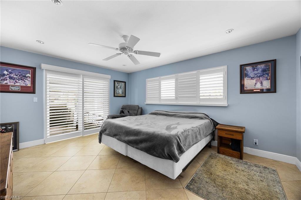 6574 Trail Boulevard Naples, FL 34108 - Photo 20 of 40 a spacious bedroom with a bed and a window