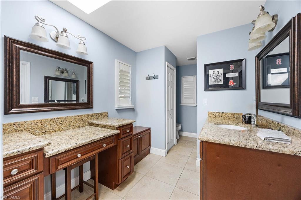 6574 Trail Boulevard Naples, FL 34108 - Photo 21 of 40 a bathroom with a granite countertop sink and a mirror