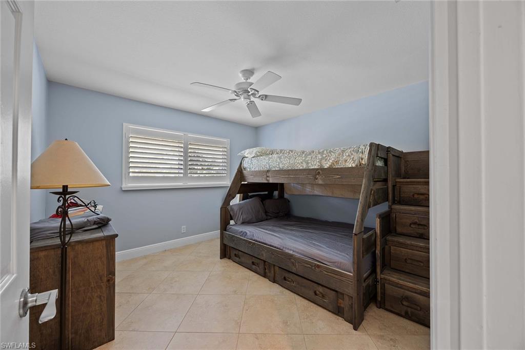 6574 Trail Boulevard Naples, FL 34108 - Photo 22 of 40 a bedroom with a bed and a window