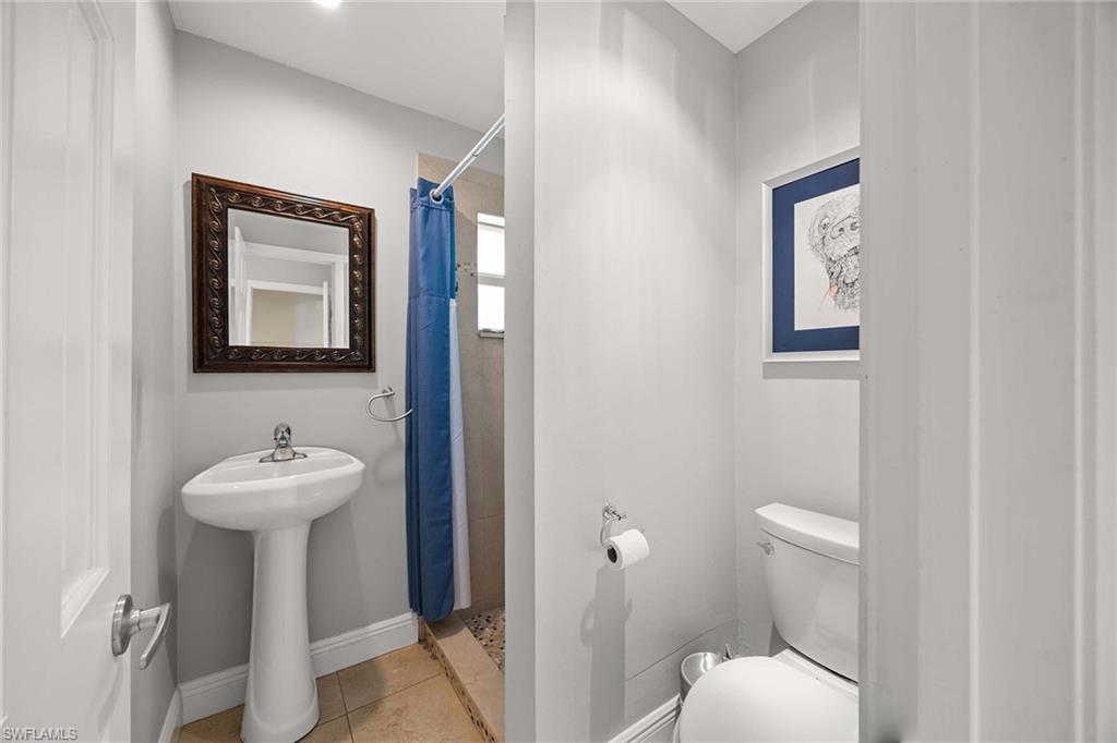6574 Trail Boulevard Naples, FL 34108 - Photo 27 of 40 a bathroom with a sink mirror and toilet