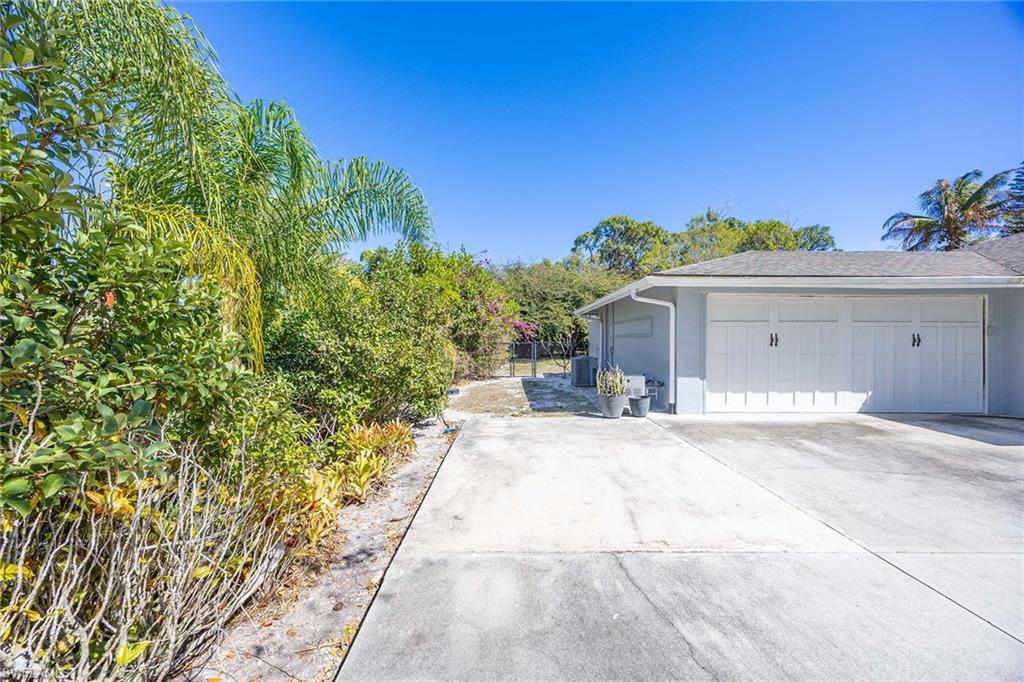 6574 Trail Boulevard Naples, FL 34108 - Photo 31 of 40 a view of a house with a yard and a garage