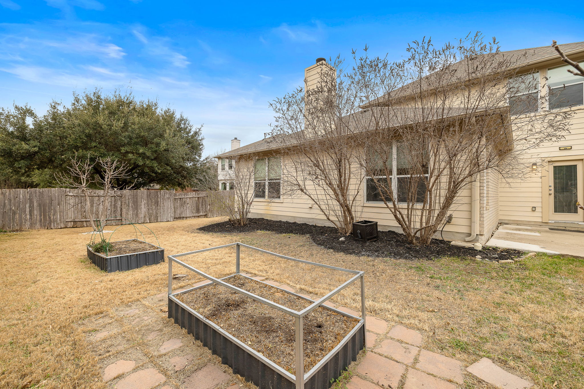 903 Fork Ridge Path Round Rock, TX 78665 - Photo 26 of 27 Spacious backyard with a patio and garden beds.