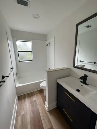 a bathroom with a sink a bathtub and a mirror