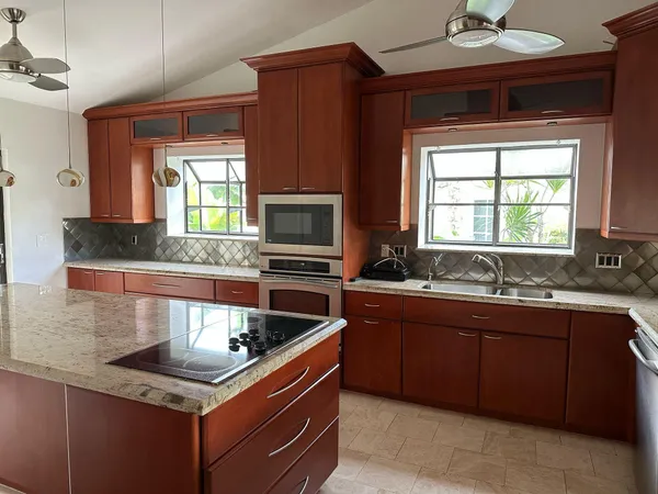 a kitchen with granite countertop a sink and wooden cabinets