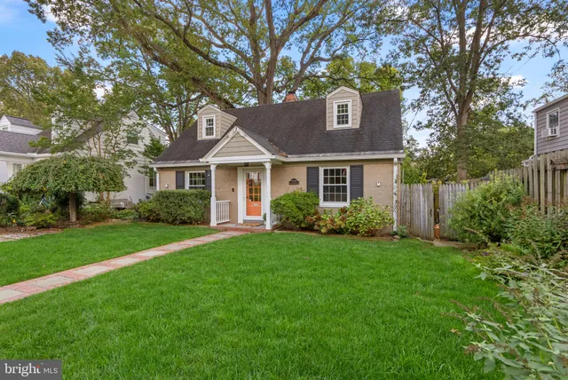 a front view of a house with a yard and trees