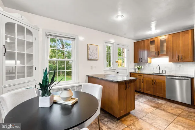 a kitchen with a table chairs sink and cabinets