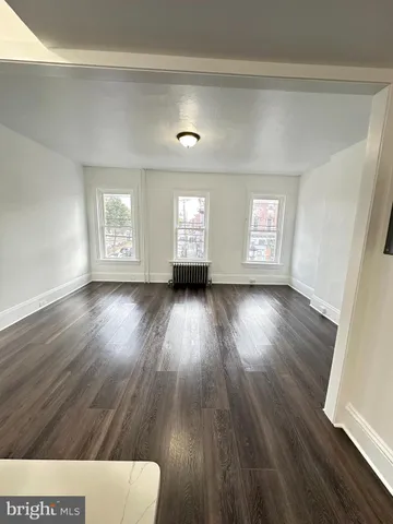 a kitchen with granite countertop white cabinets and wooden floor