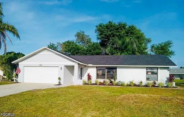 a front view of a house with a garden and yard