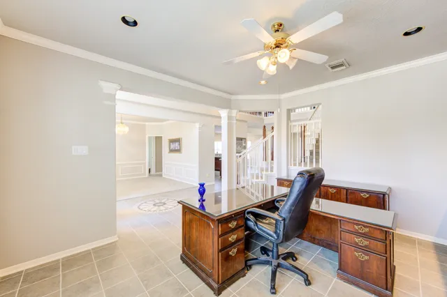 a workspace with furniture and chandelier fan