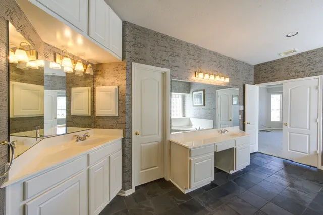 a large white kitchen with a large window