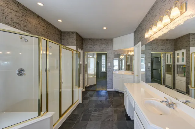 a bathroom with a tub shower and sink