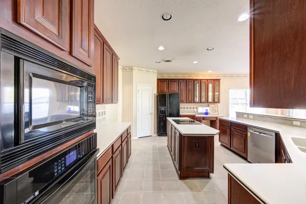 a large kitchen with a large counter top sink and stainless steel appliances