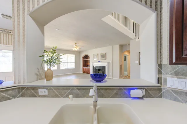 a view of a hallway with wooden floor and chandelier