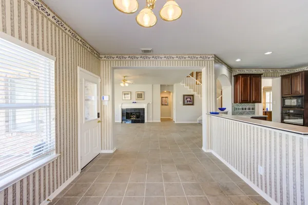 a open kitchen with cabinets a stove and a chandelier