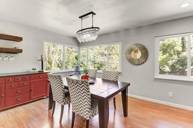 a dining room with furniture a chandelier and wooden floor