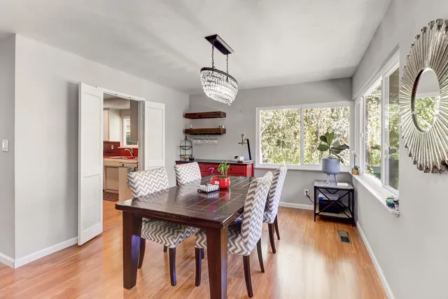 a view of a dining room with furniture a chandelier and wooden floor