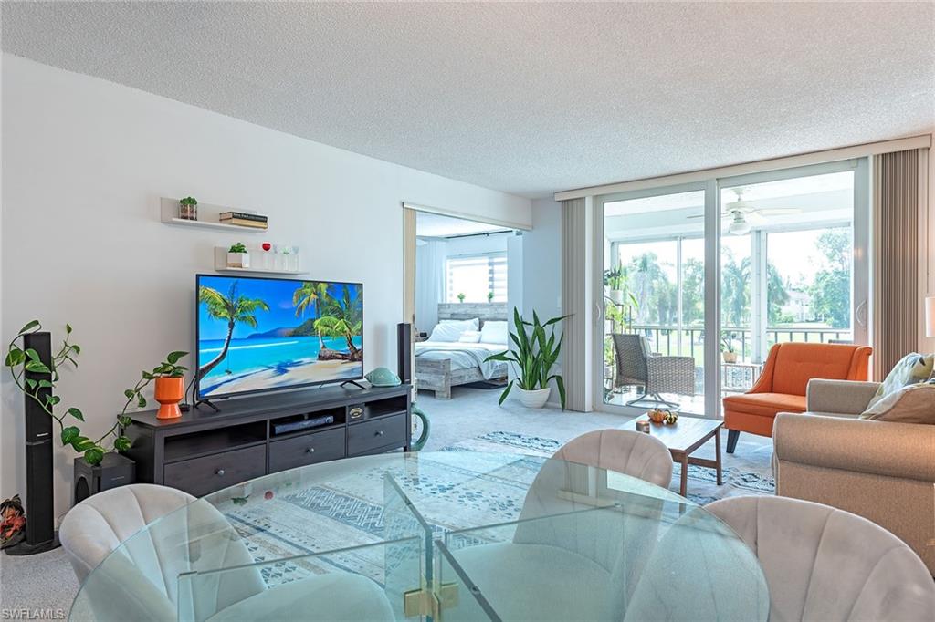 200 Forest Lakes Boulevard, Unit 201 Naples, FL 34105 - Photo 5 of 12 a living room with furniture and a flat screen tv