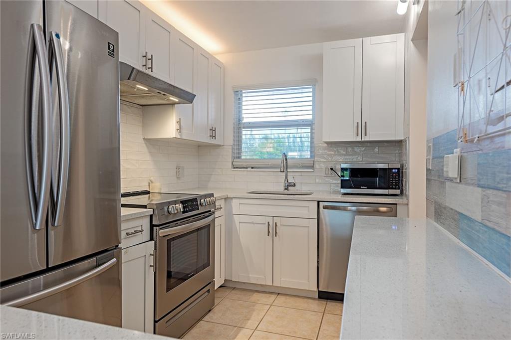 200 Forest Lakes Boulevard, Unit 201 Naples, FL 34105 - Photo 7 of 12 a kitchen with a stove microwave and a refrigerator