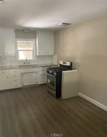a kitchen with granite countertop a sink and a stove top oven