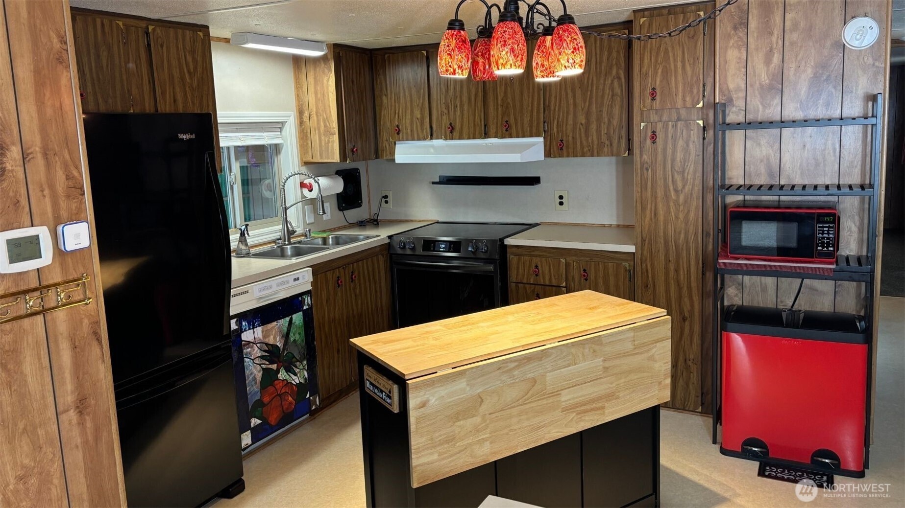 a kitchen with a sink cabinets and a stove top oven