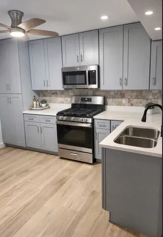 a kitchen with stainless steel appliances granite countertop a sink a stove a microwave and island