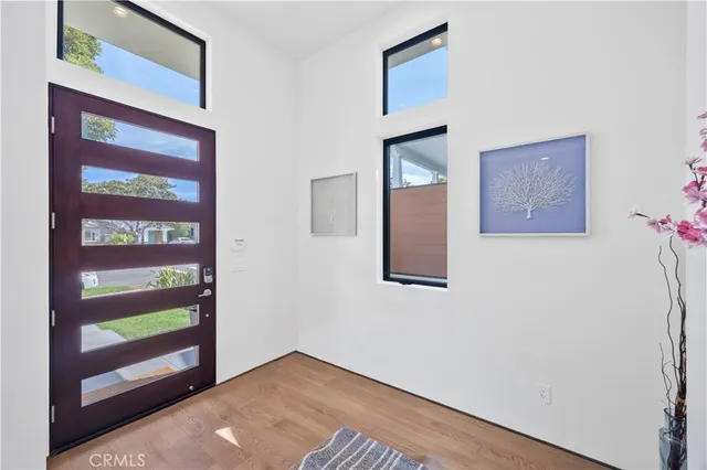 a white building with a large window and potted plants