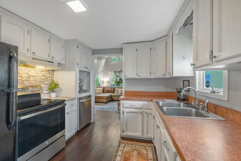 a kitchen with a sink cabinets and wooden floor
