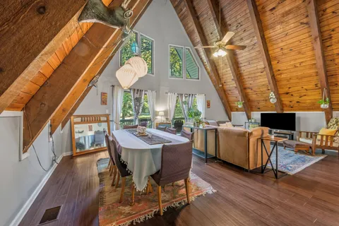 a dining room with wooden floor table and chairs