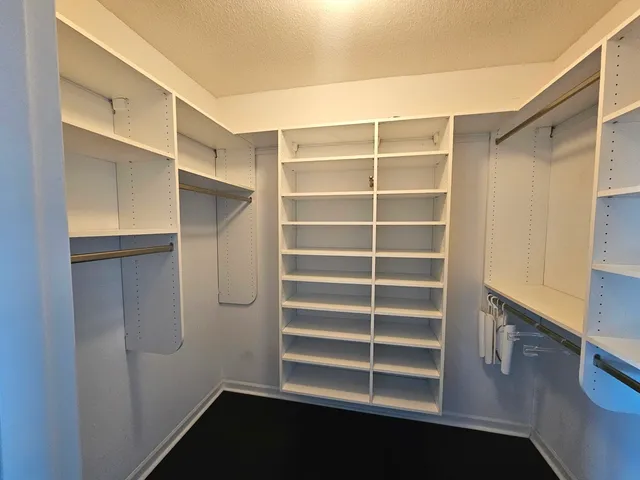 a view of walk in closet with empty racks