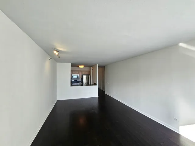 a view of a room with wooden floor and window