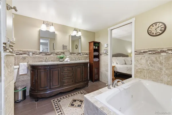 a spacious bathroom with a bathtub shower sink mirror and toilet
