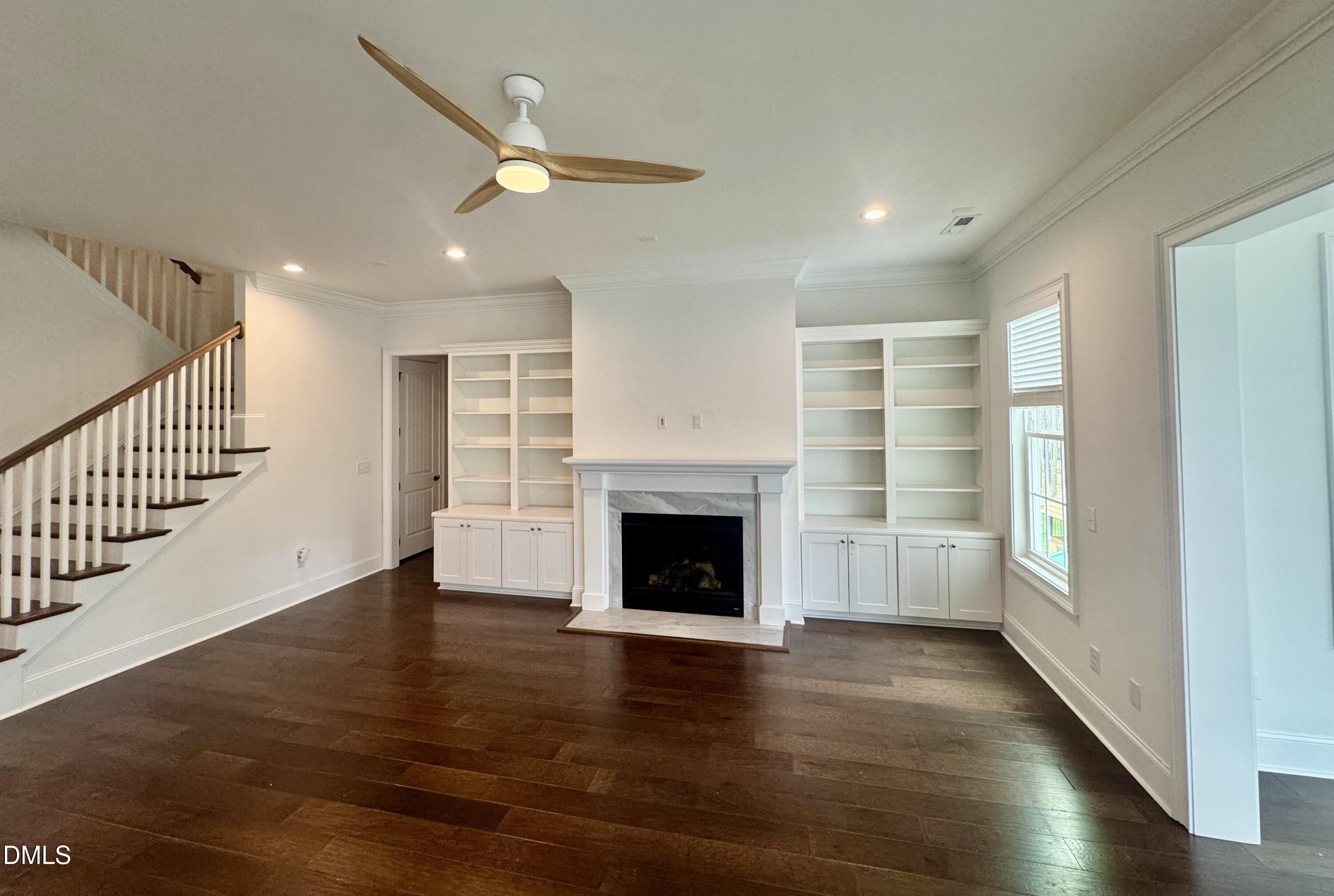 1329 Sandybrook Lane Wake Forest, NC 27587 - Photo 2 of 16 an empty room with wooden floor fireplace and windows