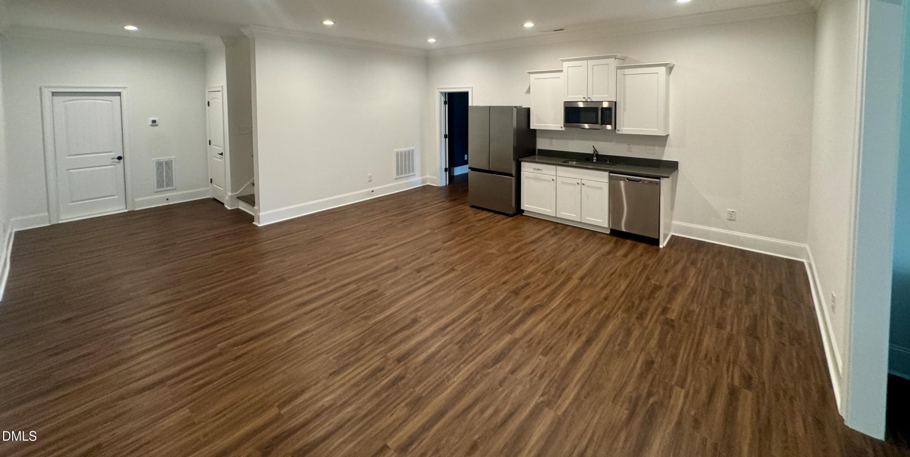 1329 Sandybrook Lane Wake Forest, NC 27587 - Photo 5 of 16 a kitchen with stainless steel appliances wooden floor and large windows