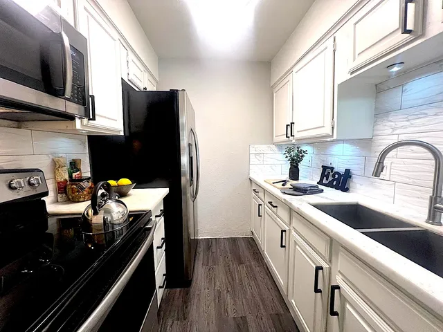 a kitchen with stainless steel appliances a sink stove and refrigerator