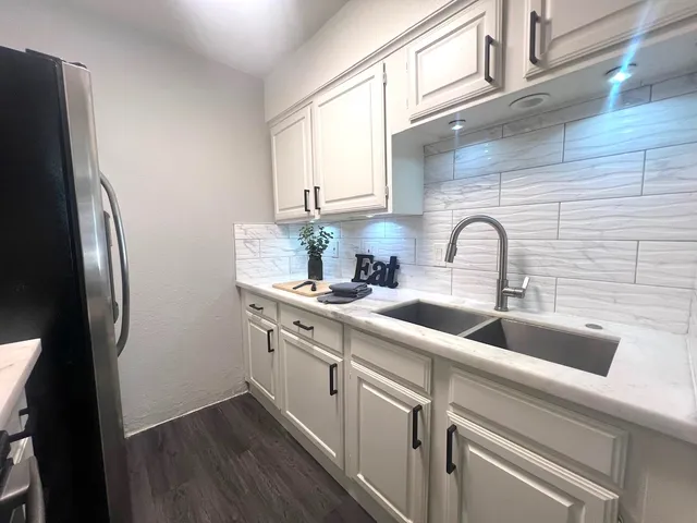 a close view of a sink a counter space and cabinets