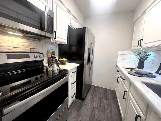 a kitchen with stainless steel appliances a stove a sink and a refrigerator