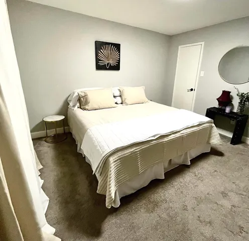 a bedroom with bed and a painting on the wall
