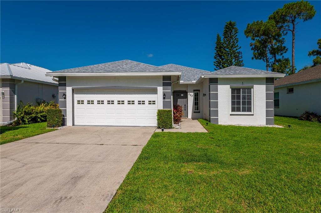 223 Stanhope Circle Naples, FL 34104 - Photo 2 of 41 White stucco exterior with gray architectural accents