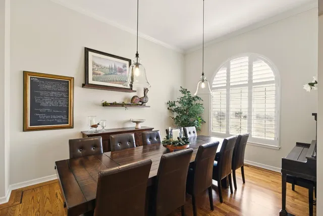 a large kitchen with stainless steel appliances granite countertop a sink a oven and a large window with wooden floor