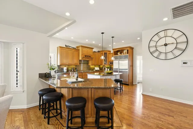 a kitchen with stainless steel appliances granite countertop a sink window and cabinets