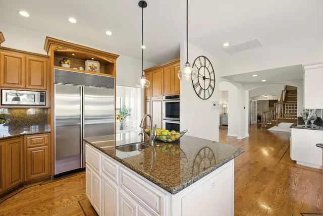 a kitchen with stainless steel appliances granite countertop a refrigerator and a sink