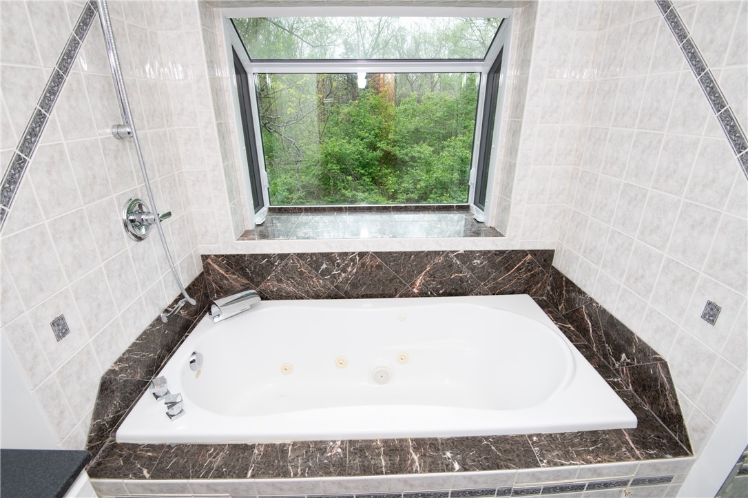 6750 Little Twin Road Germantown, OH 45327 - Photo 32 of 88 Relax in this luxurious tub, offering a tranquil view of the surrounding trees.