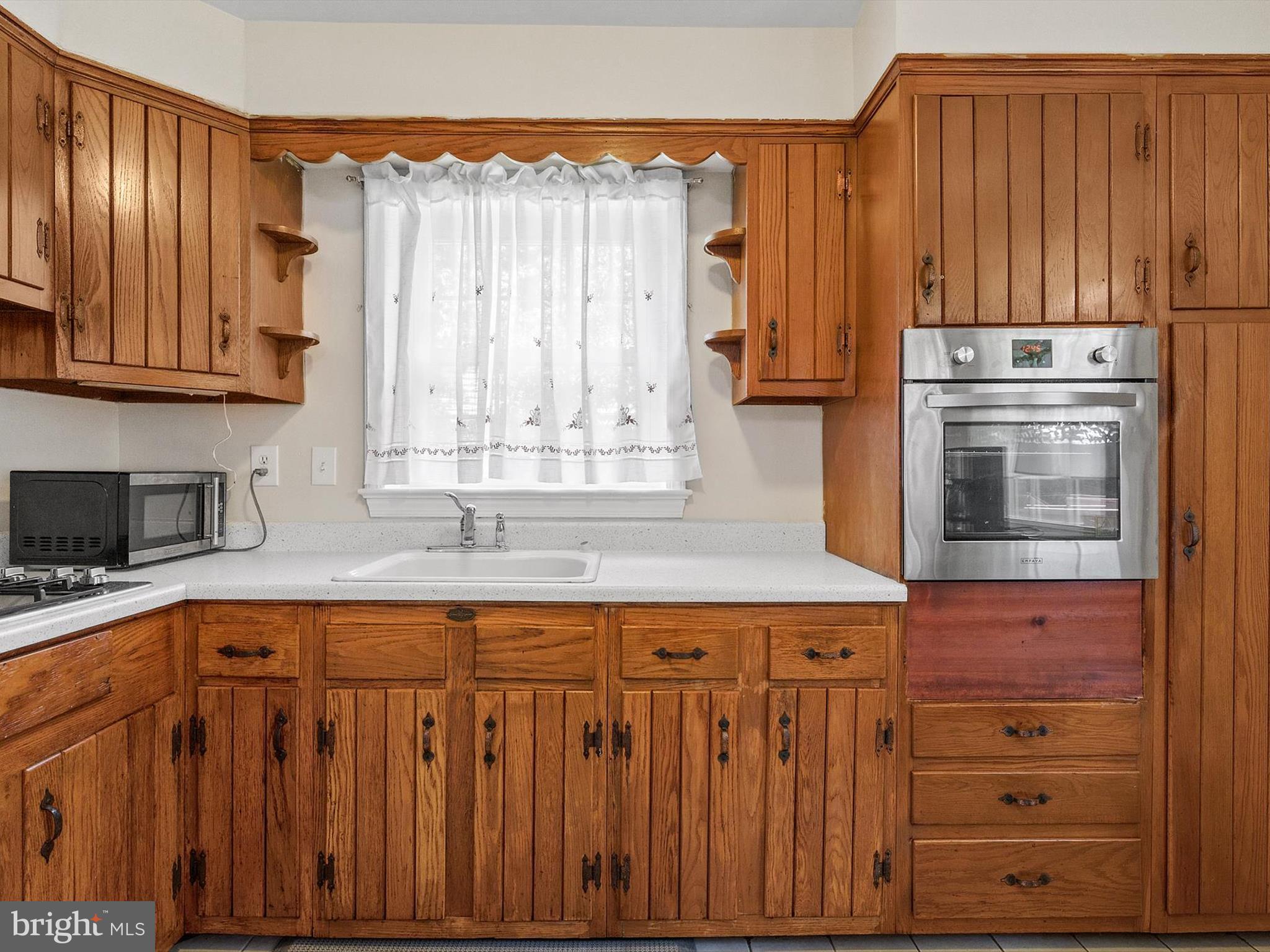 10525 Edgemont Drive Adelphi, MD 20783 - Photo 11 of 36 a kitchen with granite countertop wooden cabinets stainless steel appliances and a sink