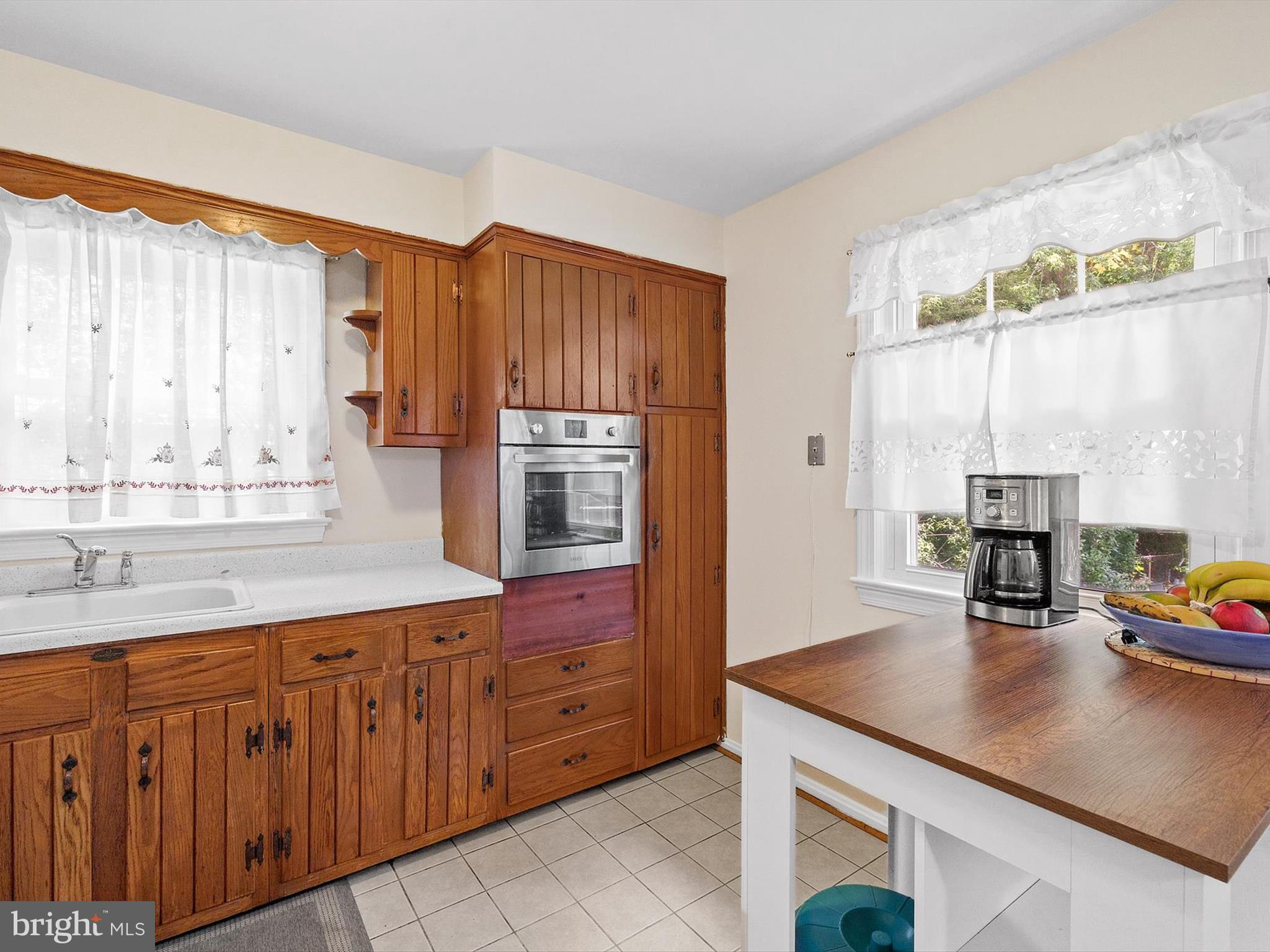 10525 Edgemont Drive Adelphi, MD 20783 - Photo 9 of 36 a kitchen with kitchen island granite countertop a sink window and cabinets