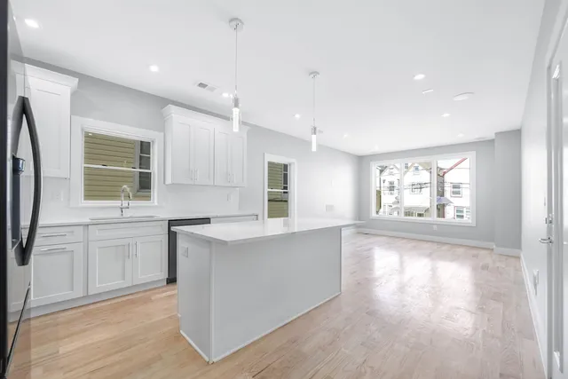 a large kitchen with stainless steel appliances granite countertop a stove a sink and a refrigerator