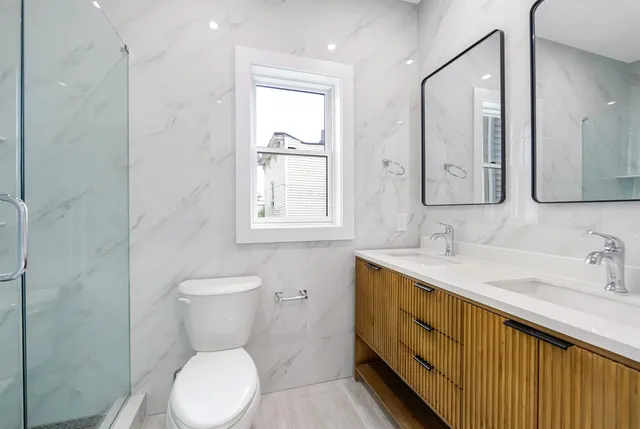 a bathroom with a toilet sink and mirror