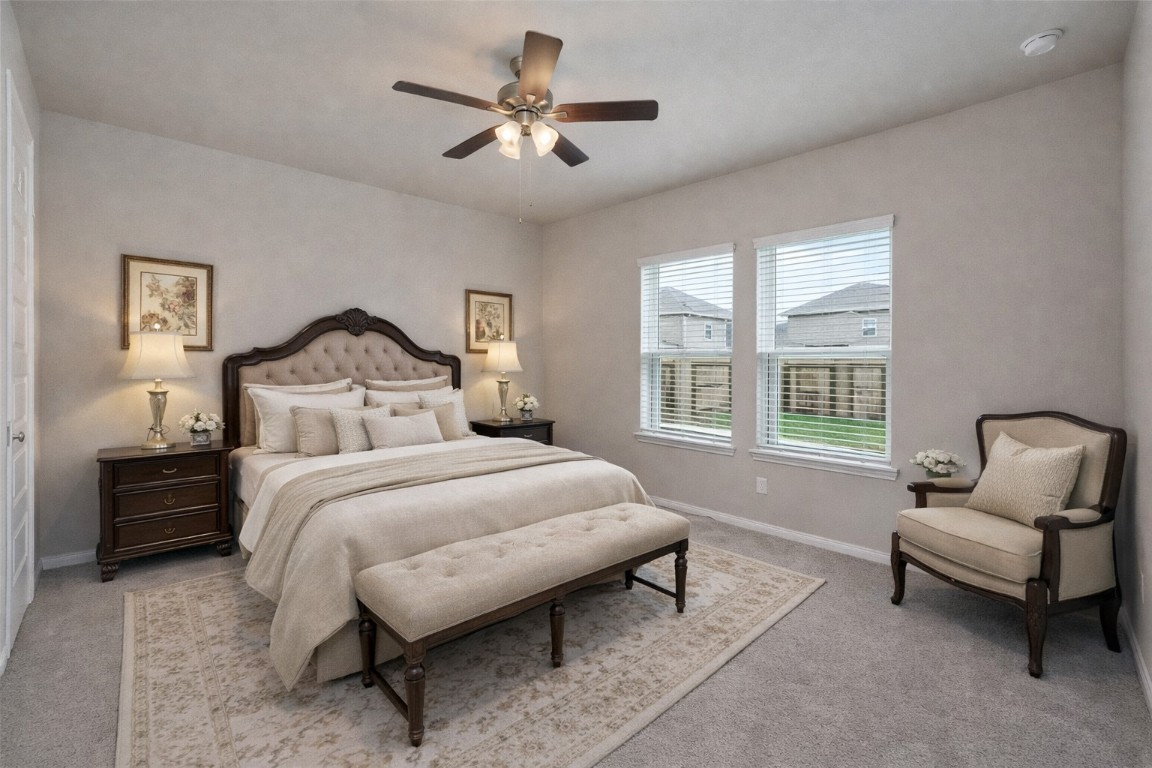 1015 Modesto Drive Rosharon, TX 77583 - Photo 16 of 37 Spacious primary bedroom filled with natural light, featuring plush carpeting, large windows, and a ceiling fan for added comfort! This inviting retreat offers plenty of space to relax and unwind after a long day. *Virtually Staged*